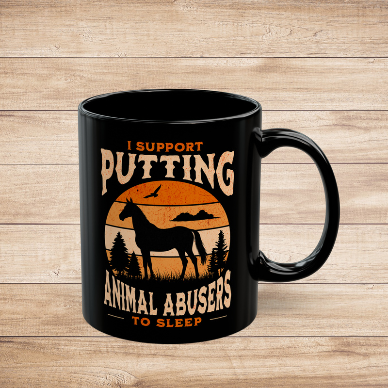 Black 11oz ceramic mug (right view) with horse silhouette and rustic sunset design, reading “I Support Putting Animal Abusers to Sleep,” on wood background.