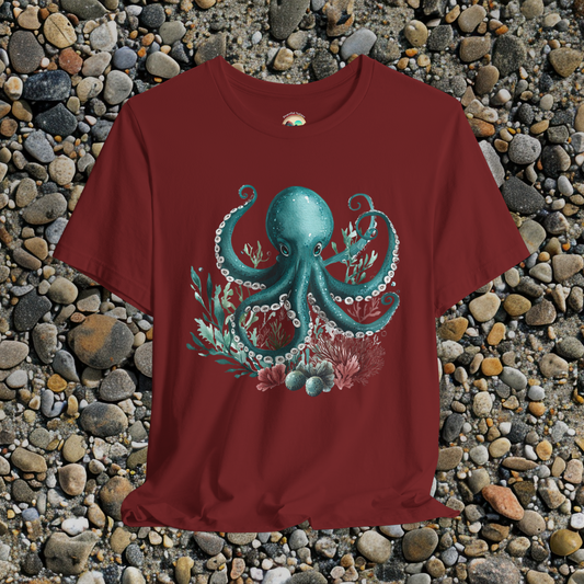 Teal watercolor octopus marine design printed on cardinal red cotton tee, beach rock background