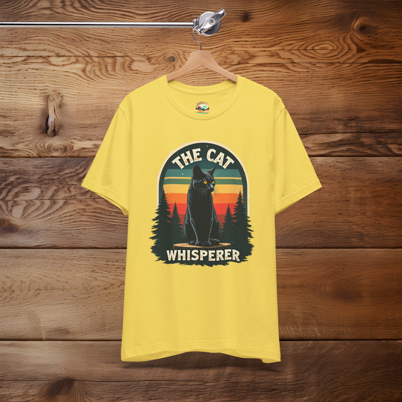 The Cat Whisperer T-Shirt in maize yellow, featuring a black cat among trees with a colorful retro sunset background