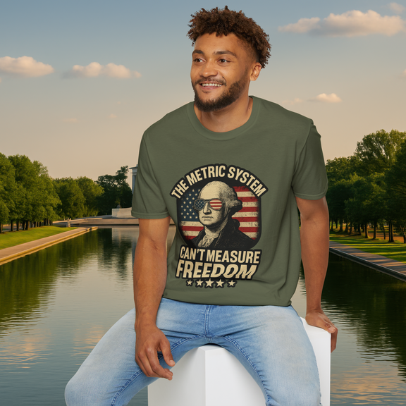 Happy male model wearing a military green 'The Metric System Can’t Measure Freedom' T-shirt featuring George Washington in flag sunglasses and vintage style