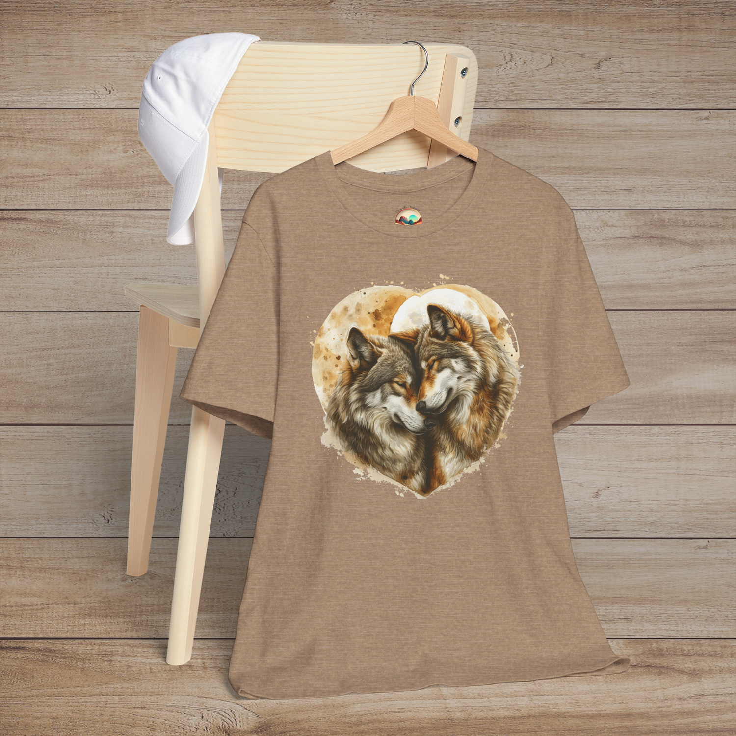 Heather tan t-shirt with realistic artwork of two wolves nestled together inside a heart shape, highlighting connection and wilderness
